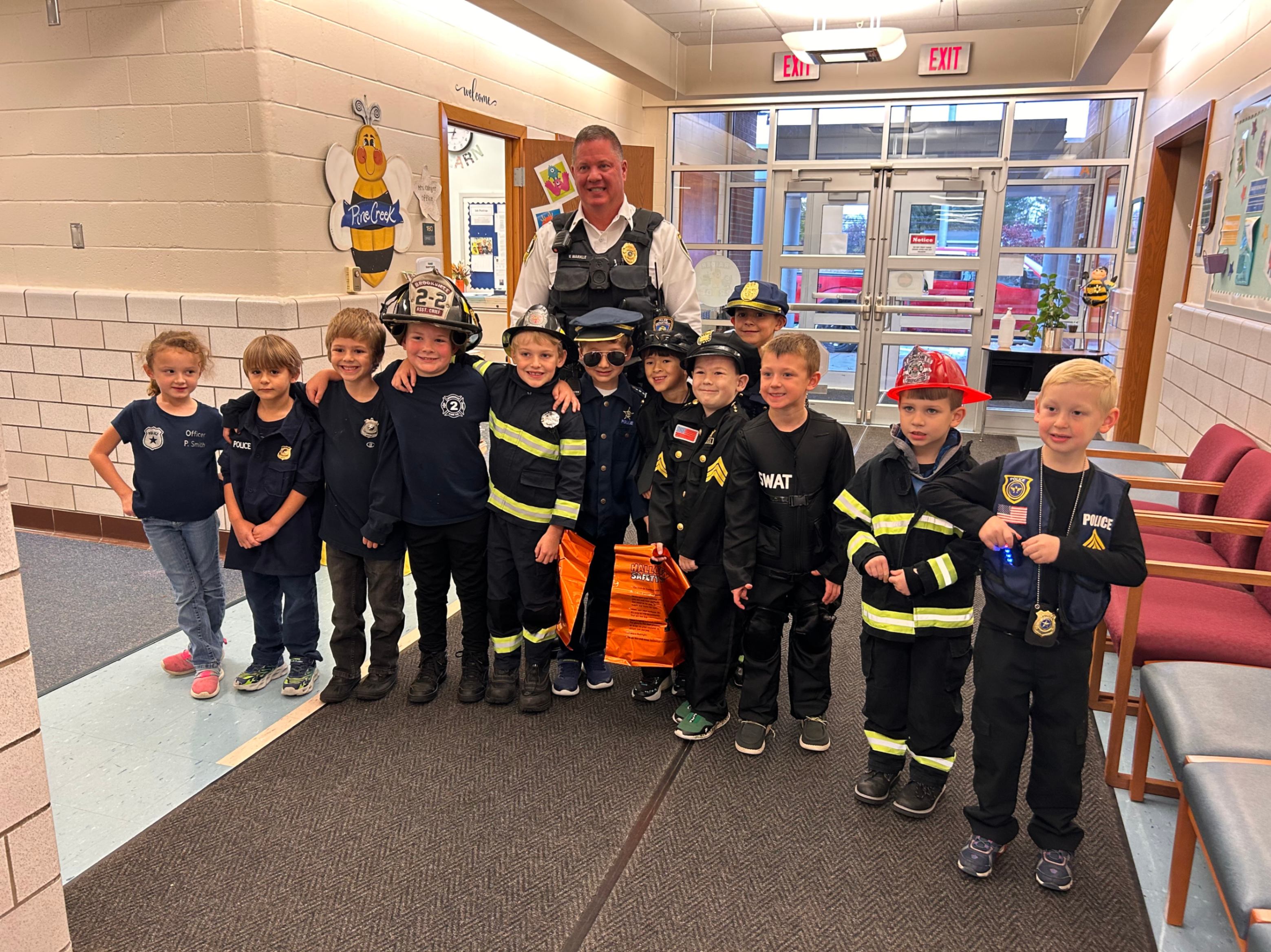 Chief Markle poses for a photo with Pinecreek students on Halloween.